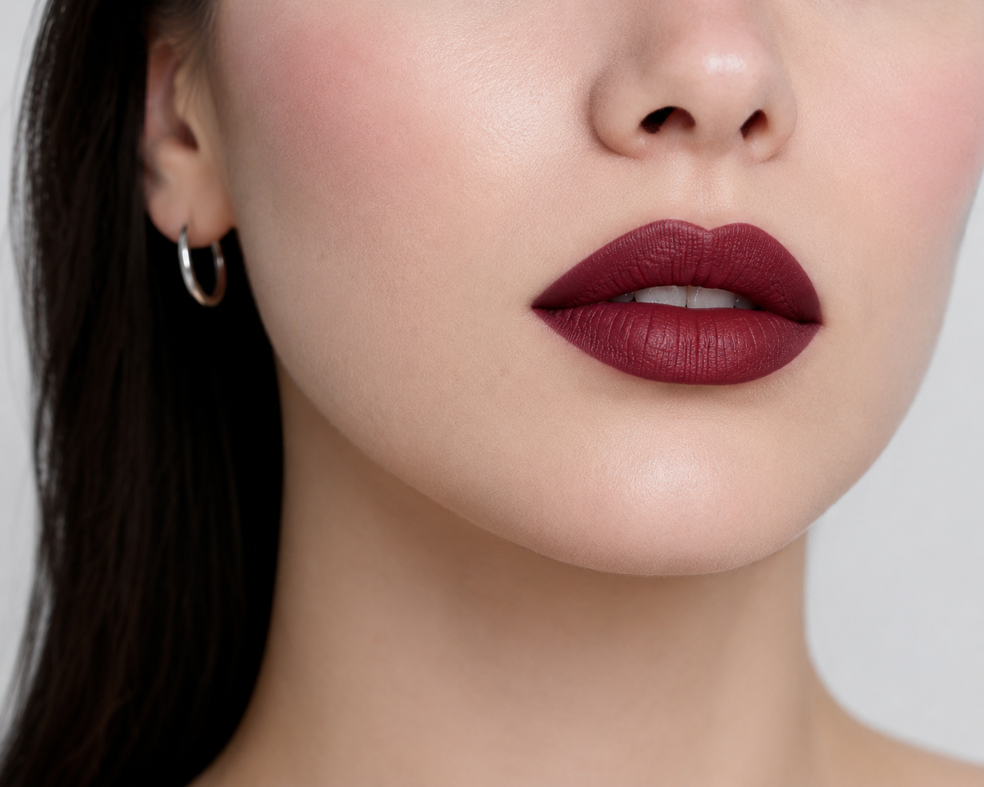 Woman with cool undertone skin wearing deep burgundy or plum lipstick