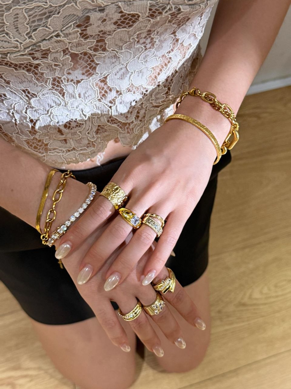 Hand detail showing stacked gold rings with diamond pavé settings, demonstrating how diamonds and gold layer together without competing