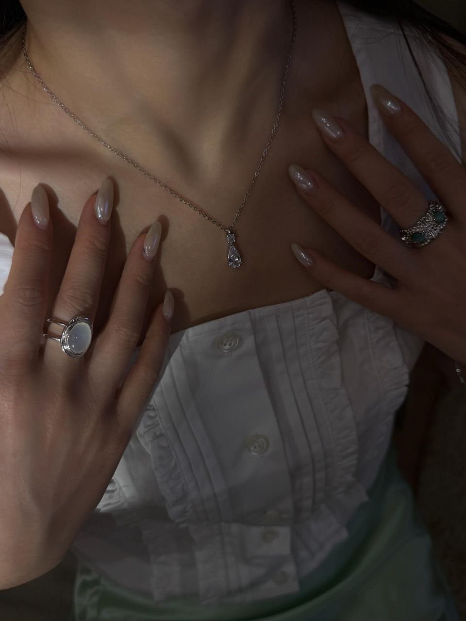Close-up of silver pearl ring with diamond accent and silver necklace pendant, showing how pearls work as statement rings