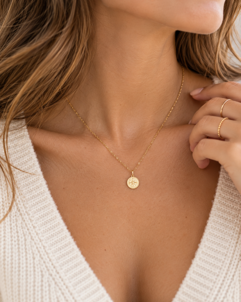 Close-up of a fine gold pendant necklace at the collarbone